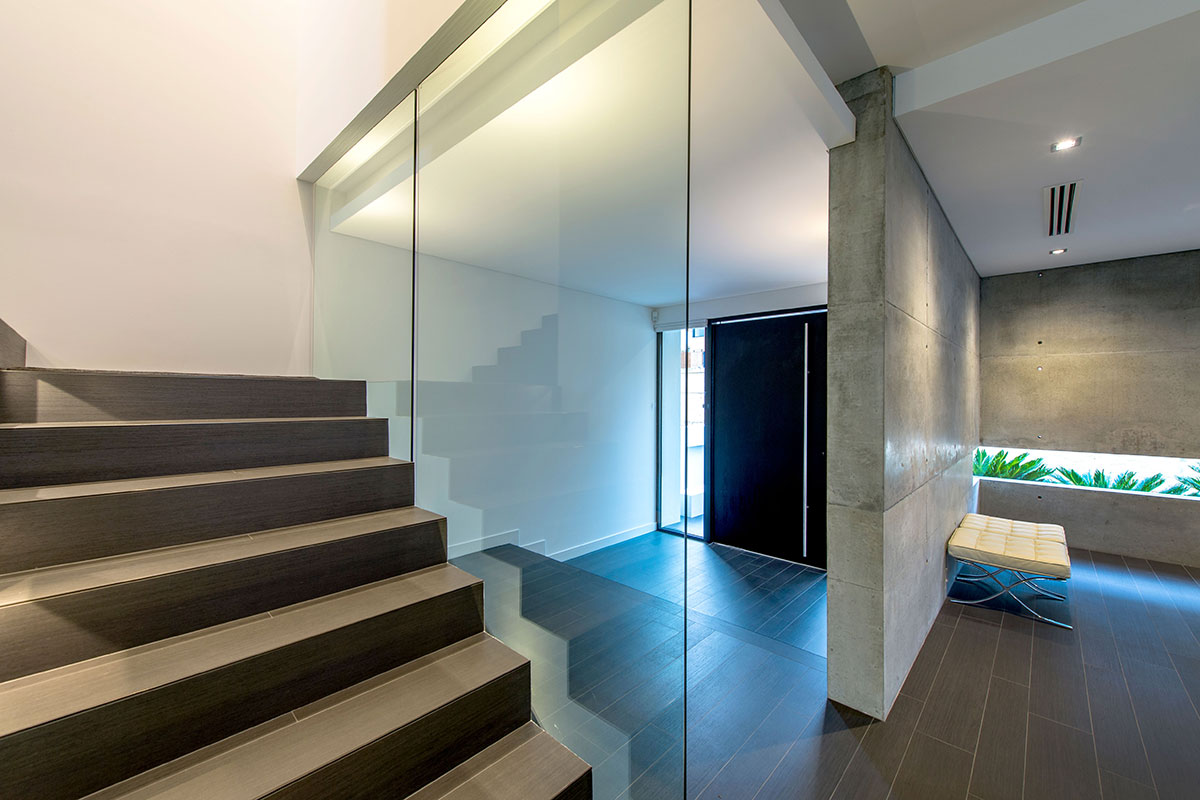 Private entrance way with floor to ceiling glass large timber doors are features in this custom built mosman park home